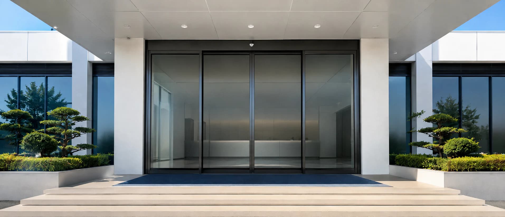 Black-framed bi-parting automatic sliding door at a modern commercial entrance