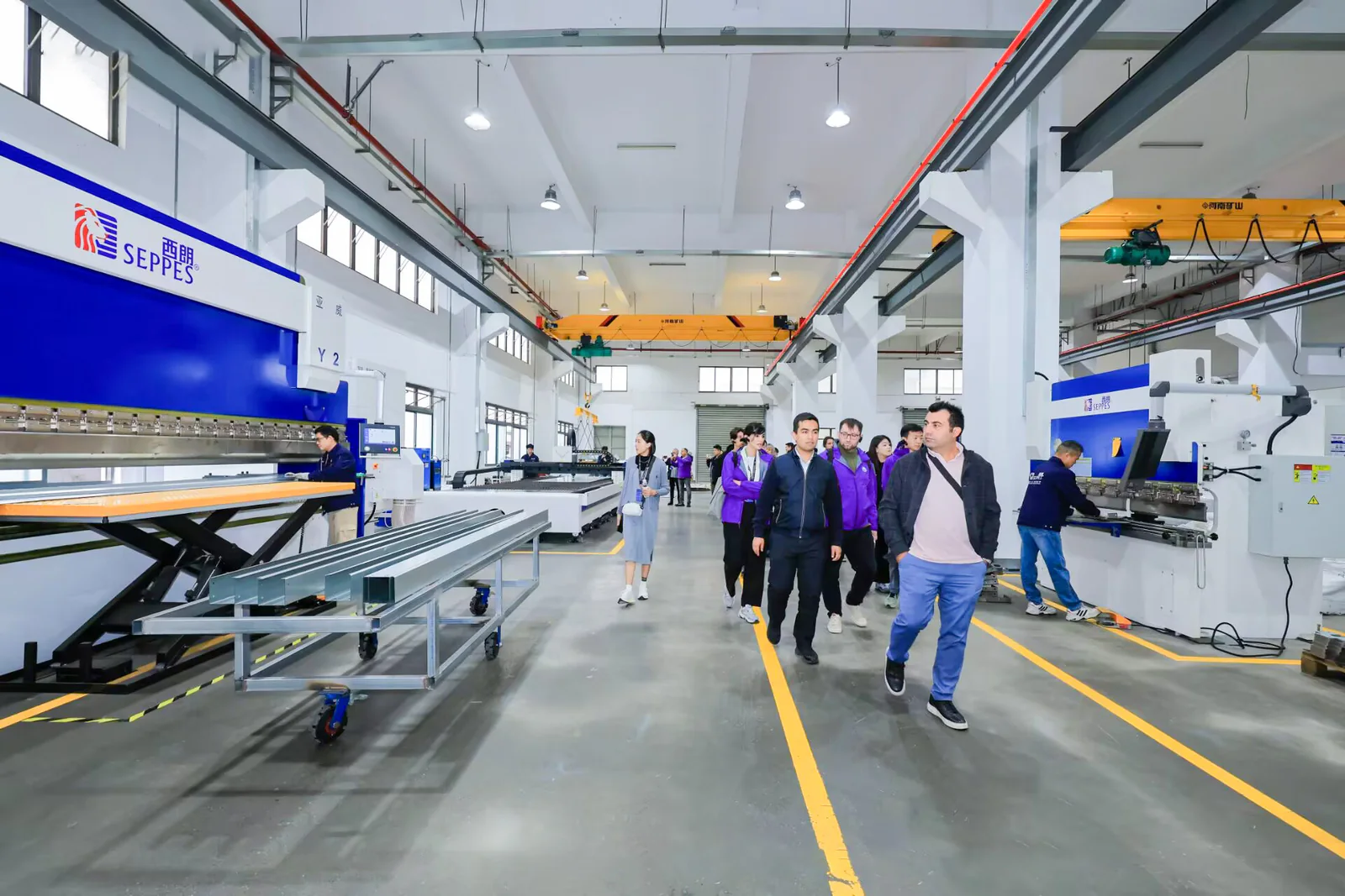 SEPPES production team and visitors reviewing manufacturing equipment