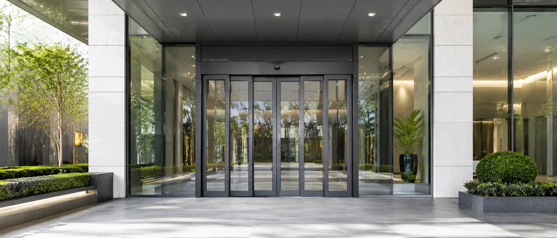 Telescopic automatic sliding door with multiple framed moving panels at a commercial entrance